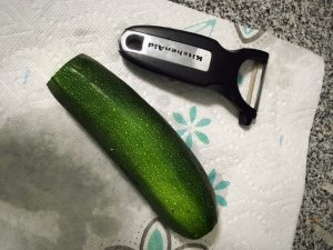 zucchini next to vegetable peeler