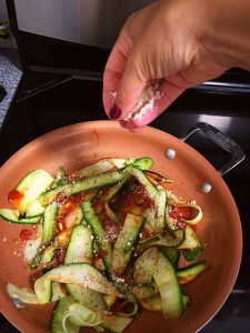zucchini pasta in pan with toppings 
